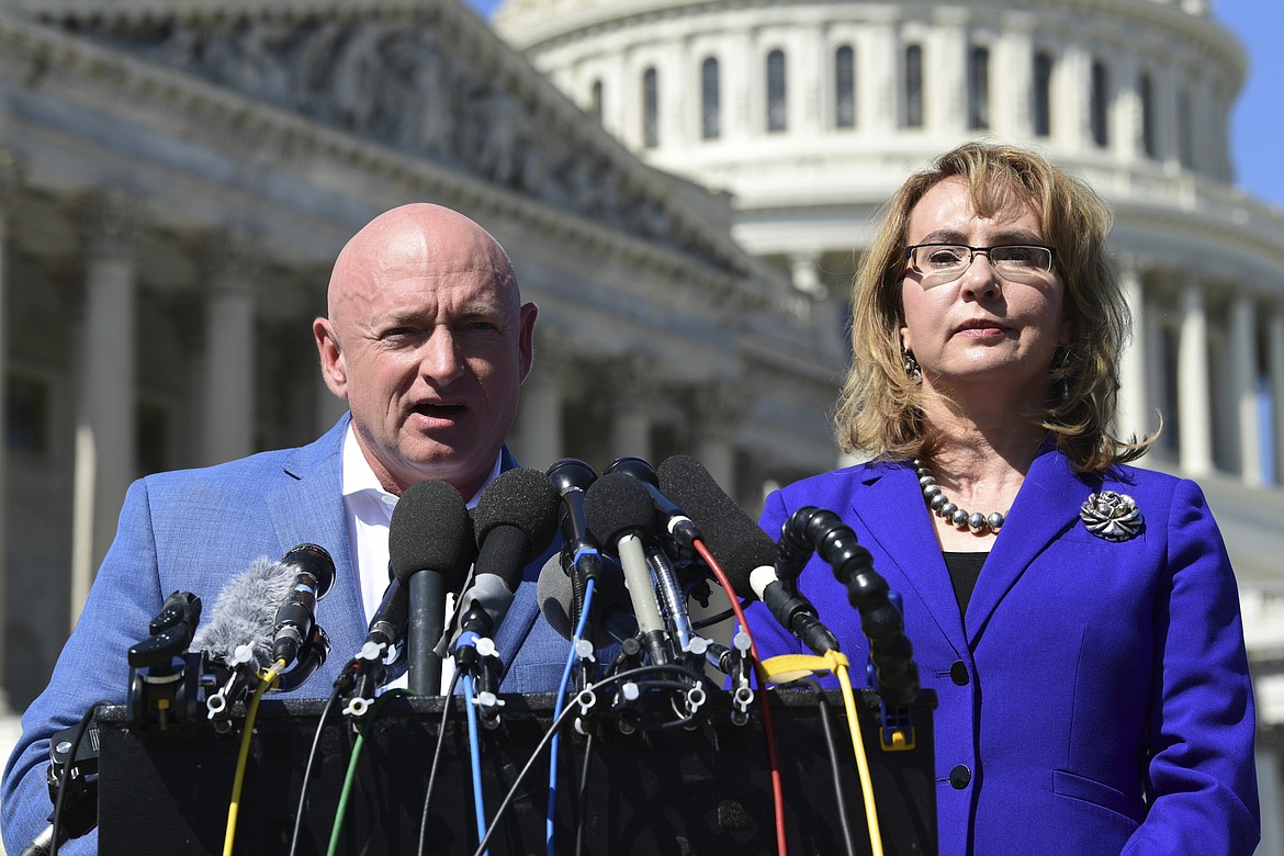 Former Rep. Gabrielle Giffords, D-Ariz., right, listens as her husband Mark Kelly, left, speaks on Capitol Hill in Washington, Monday, Oct. 2, 2017, about the mass shooting in Las Vegas. Giffords, was a congresswoman when she was shot in an assassination attempt in 2011. (AP Photo/Susan Walsh)