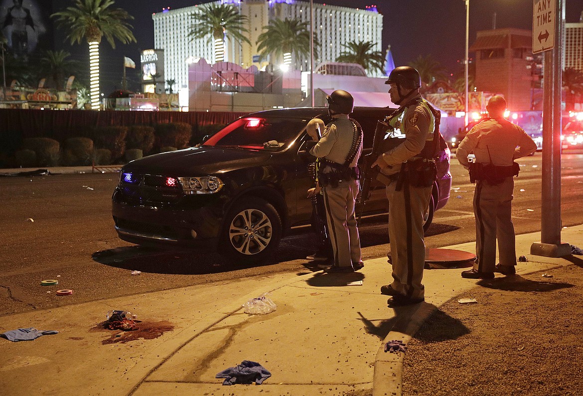 Police stand at the scene of a shooting along the Las Vegas Strip, Monday, Oct. 2, 2017, in Las Vegas. Multiple victims were being transported to hospitals after a shooting late Sunday at a music festival on the Las Vegas Strip. (AP Photo/John Locher)