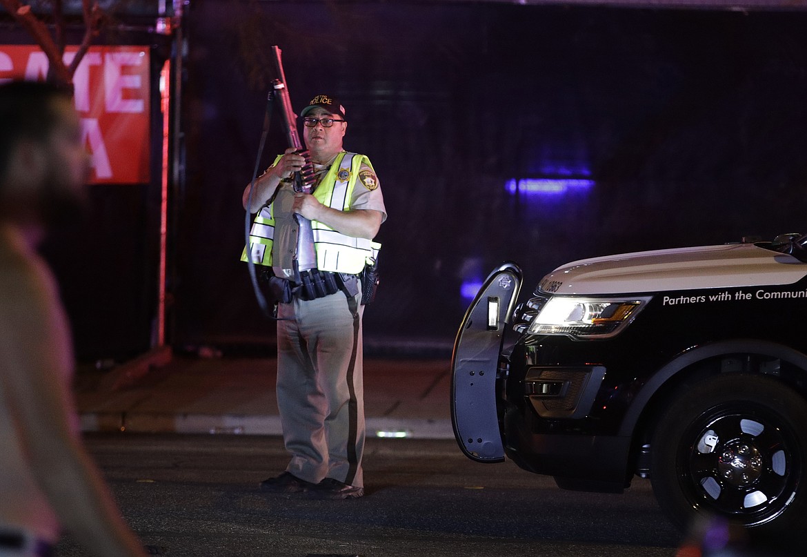 A police officer stands at the scene of a shooting along the Las Vegas Strip, Monday, Oct. 2, 2017, in Las Vegas. Multiple victims were being transported to hospitals after a shooting late Sunday at a music festival on the Las Vegas Strip. (AP Photo/John Locher)