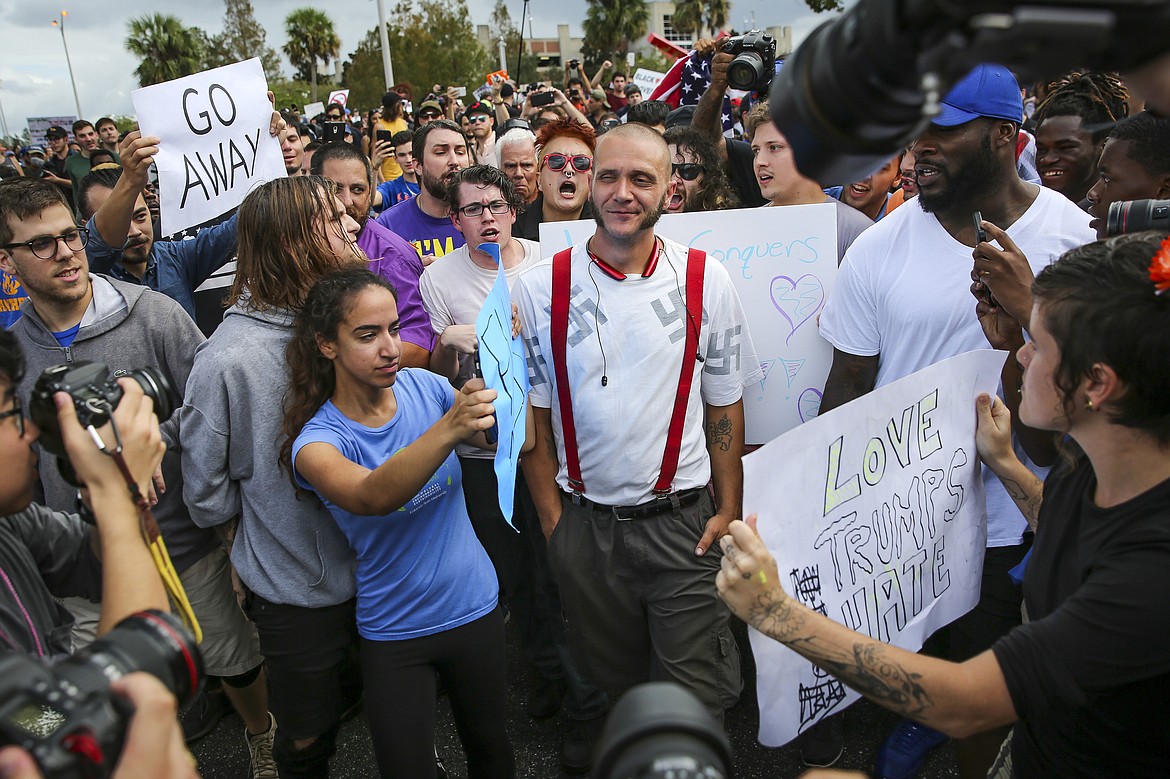 Protesters confront a man wearing a shirt with swastikas outside a University of Florida auditorium where white nationalist Richard Spencer was preparing to speak, Thursday, Oct. 19, 2017 in Gainesville, Fla. (Will Vragovic/Tampa Bay Times via AP)