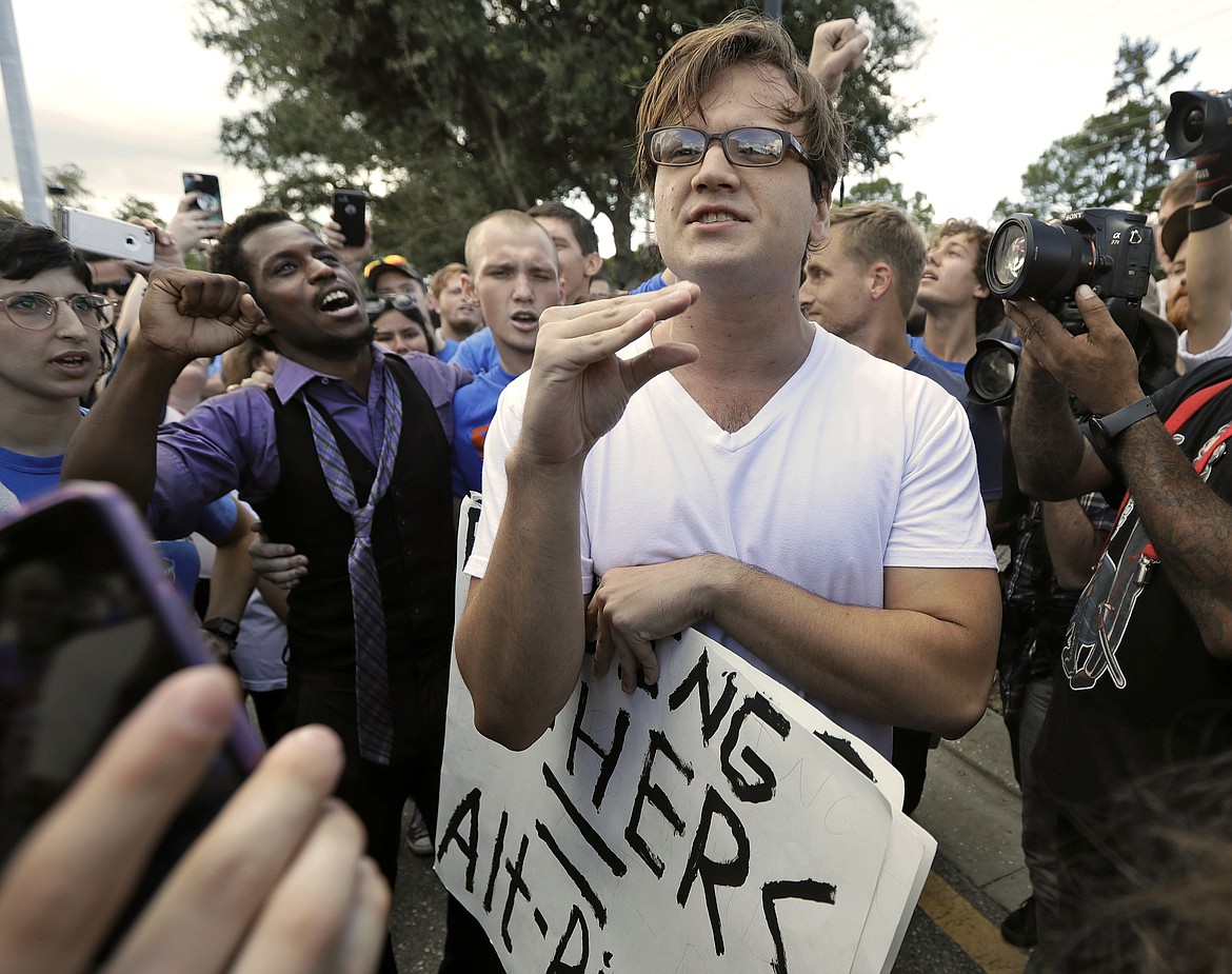 A supporter of white nationalist Richard Spencer stands amid of crowd of protesters after Spencer spoke at University of Florida in Gainesville, Thursday, Oct. 19, 2017.  (AP Photo/Chris O&#146;Meara)