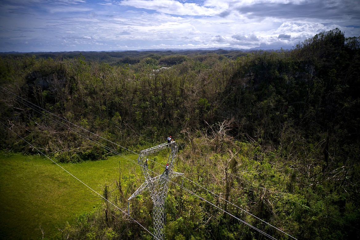 FILE - In this Oct. 15, 2017, file photo, Whitefish Energy Holdings workers stand on towers to restore lines damaged by Hurricane Maria in Barceloneta, Puerto Rico. The Trump administration said Oct. 27 it had no involvement in the decision to award a $300 million contract to help restore Puerto Rico&#146;s power grid to a tiny Montana company in Interior Secretary Ryan Zinke&#146;s hometown. White House spokesman Raj Shah said that federal officials played no role in the selection of Whitefish Energy Holdings by the Puerto Rico Electric Power Authority.(AP Photo/Ramon Espinosa, File)