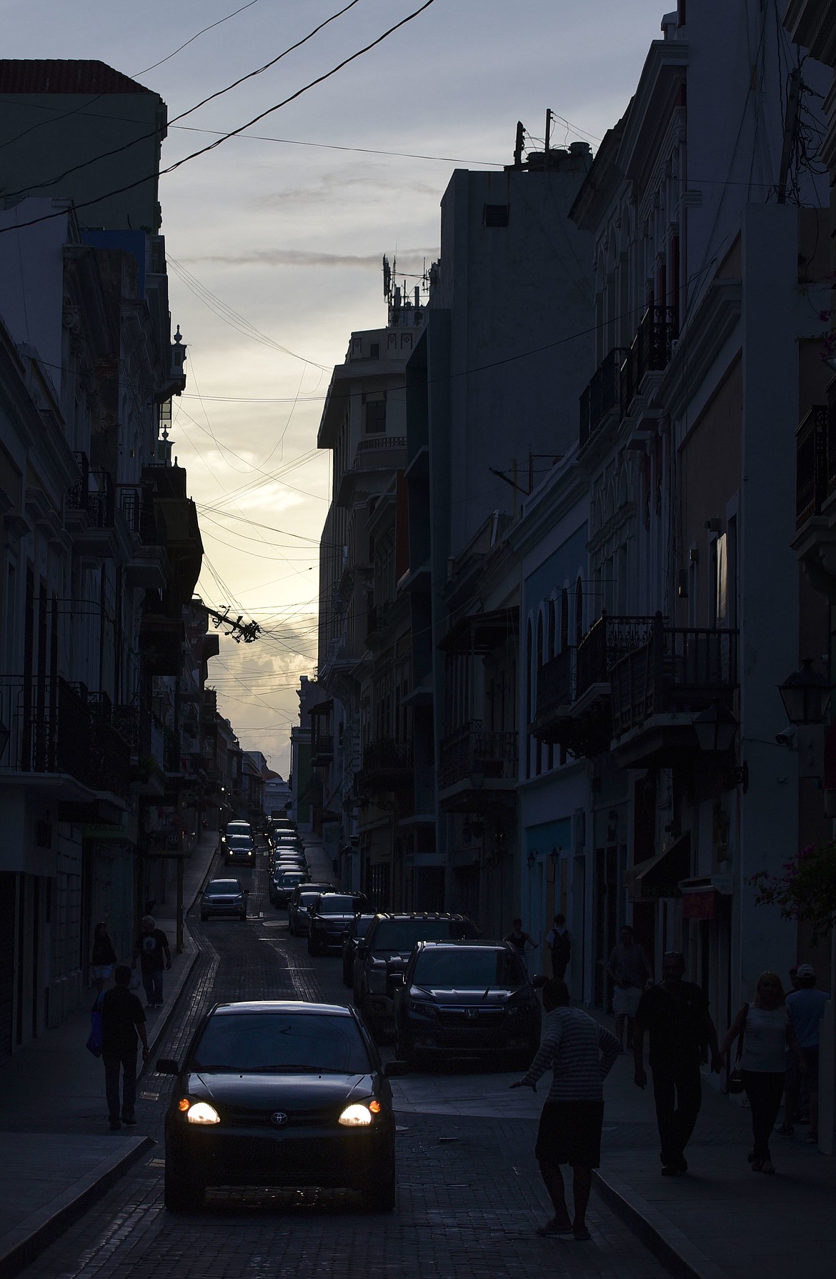 In this Friday, Oct. 20, 2017 photo, power is out along Fortaleza street, one month after Hurricane Maria, in Old San Juan, Puerto Rico. Hotels are closed. Restaurants have no power. Old San Juan is deserted. Tourism is practically nonexistent in Puerto Rico right now. (AP Photo/Carlos Giusti)