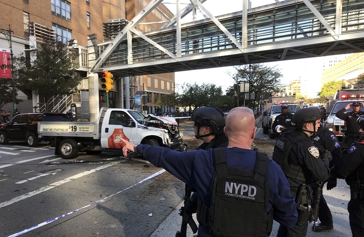 In this photo provided by the New York City Police Department, officers respond to a report of gunfire along West Street near the pedestrian bridge at Stuyvesant High School in lower Manhattan in New York, Tuesday, Oct. 31, 2017. (Martin Speechley/NYPD via AP)