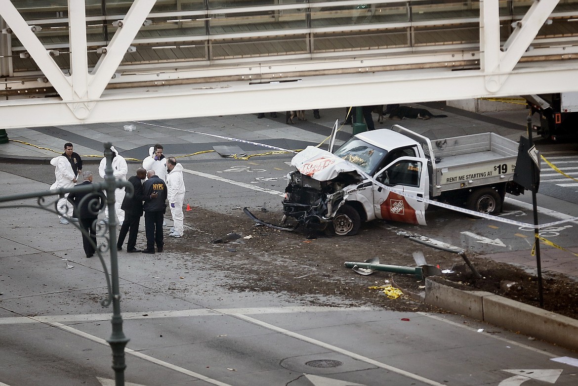 Authorities stand near a damaged Home Depot truck after a motorist drove onto a bike path near the World Trade Center memorial, striking and killing several people Tuesday, Oct. 31, 2017, in New York. (AP Photo/Bebeto Matthews)