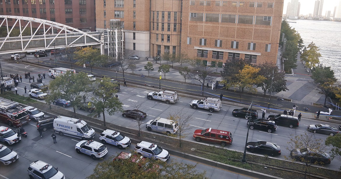 Authorities investigate the wreckage of a Home Depot truck, top left, and a body under a white cloth, top right, after a motorist drove the truck down the bike path Tuesday Oct. 31, 2017, in New York. The motorist drove onto the busy bicycle path near the World Trade Center memorial Tuesday, killing several. (AP Photo/Bebeto Matthews)