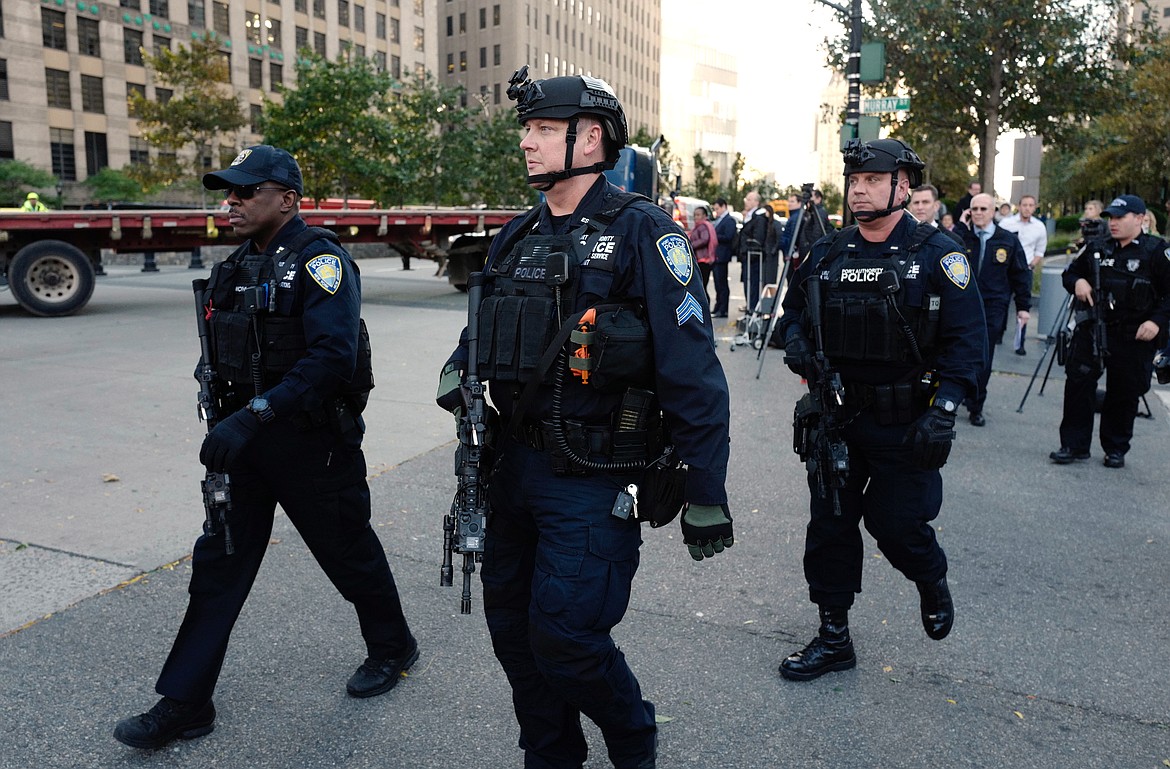 New York Police Department officers gather near the scene after a motorist drove onto a busy bicycle path near the World Trade Center memorial and struck several people Tuesday, Oct. 31, 2017, in New York. (AP Photo/Mark Lennihan)