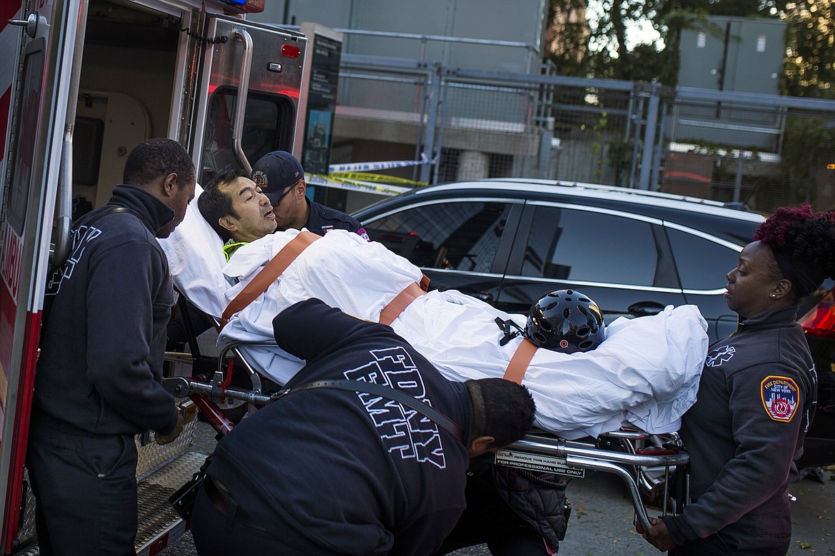 Emergency personnel carry a man into an ambulance after a motorist drove onto a busy bicycle path near the World Trade Center memorial and struck several people Tuesday, Oct. 31, 2017, in New York. (AP Photo/Andres Kudacki)