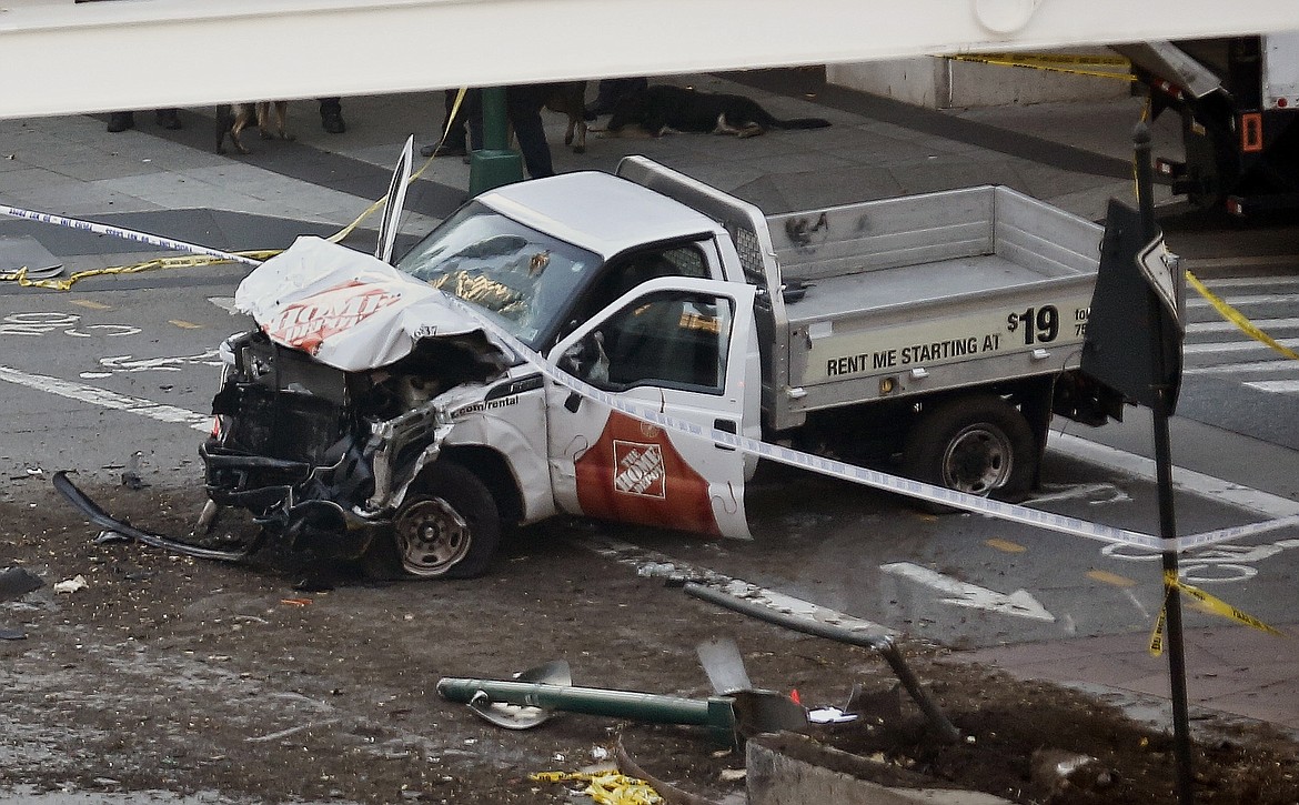 Police tape rests on a damaged Home Depot truck sits after a motorist drove onto a bike path near the World Trade Center memorial, striking and killing several people Tuesday, Oct. 31, 2017, in New York. (AP Photo/Bebeto Matthews)