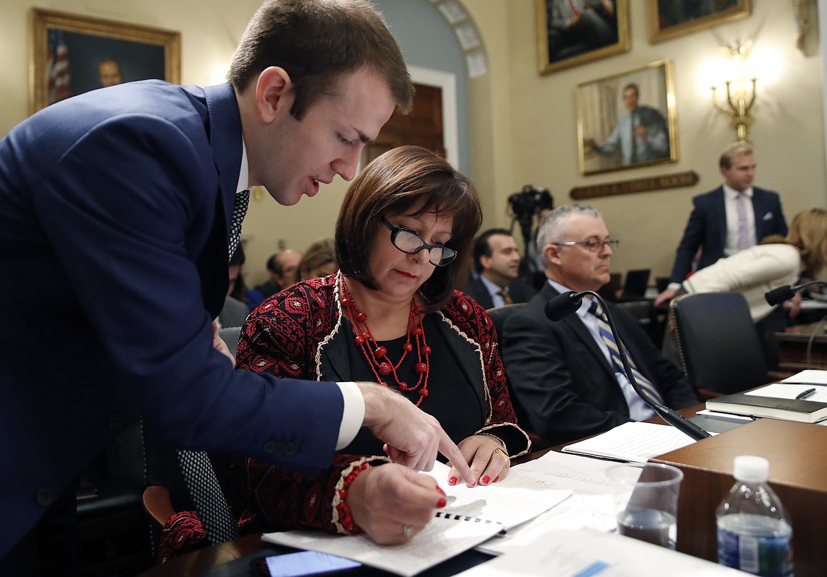 An aide, left, assists Natalie Jaresko, executive director, and Noel Zamot, revitalization coordinator, both of the financial oversight and management board for Puerto Rico, before the start of a House Committee on Natural Resources hearing to examine challenges in Puerto Rico's recovery and the role of the financial oversight and management board, on Capitol Hill, Tuesday, Nov. 7, 2017 in Washington. (AP Photo/Alex Brandon)