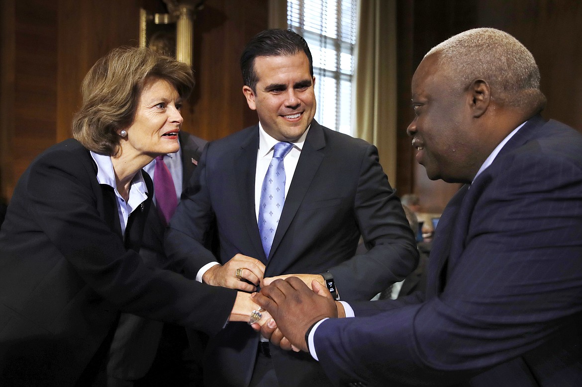 Senate Committee on Energy and Natural Resources Chair Sen. Lisa Murkowski, R-Alaska, left, greets Puerto Rico Gov. Ricardo Rossello, center, and U.S. Virgin Islands Gov. Kenneth Mapp, at a hearing on hurricane recovery, Tuesday, Nov. 14, 2017, on Capitol Hill in Washington. (AP Photo/Jacquelyn Martin)