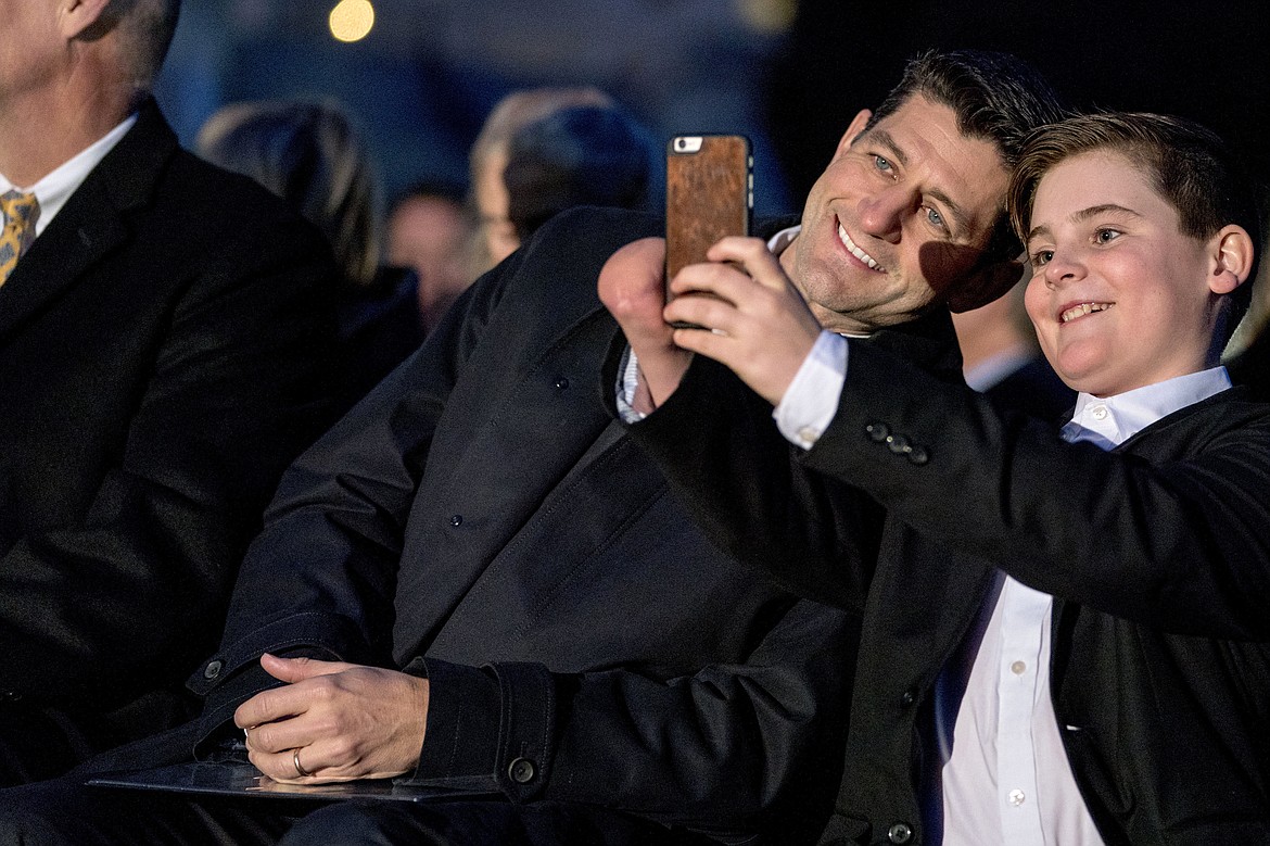 House Speaker Paul Ryan of Wis., left, and Ridley Brandmayr of Bozeman, Mont., right, take a photograph before lighting the 2017 Capitol Christmas Tree during a ceremony on the West Lawn of the Capitol Building, Wednesday, Dec. 6, 2017, in Washington. The Capitol Christmas Tree has been a tradition since 1964, and this year's tree was chosen from Kootenai National Forest in Montana. (AP Photo/Andrew Harnik)