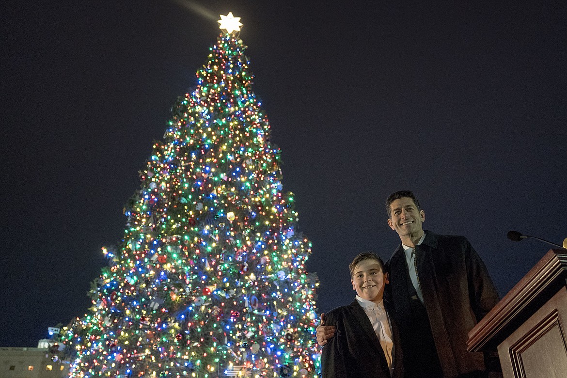 The 2017 Capitol Christmas Tree is lit by House Speaker Paul Ryan of Wis., right, and Ridley Brandmayr of Bozeman, Mont., left, on the West Lawn of theU.S. Capitol, Wednesday, Dec. 6, 2017, in Washington. The Capitol Christmas Tree has been a tradition since 1964, and this year's tree was chosen from Kootenai National Forest in Montana. (AP Photo/Andrew Harnik)