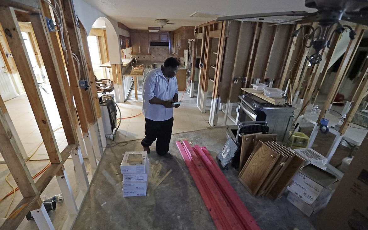 FILE - In this Nov. 17, 2017, file photo, George Dorsey walks through his hurricane-damaged home in Houston. If House Republicans have their way, victims of hurricanes in Texas and Florida could deduct their losses on their taxes. But victims of the California wildfires no longer could. (AP Photo/David J. Phillip, File)