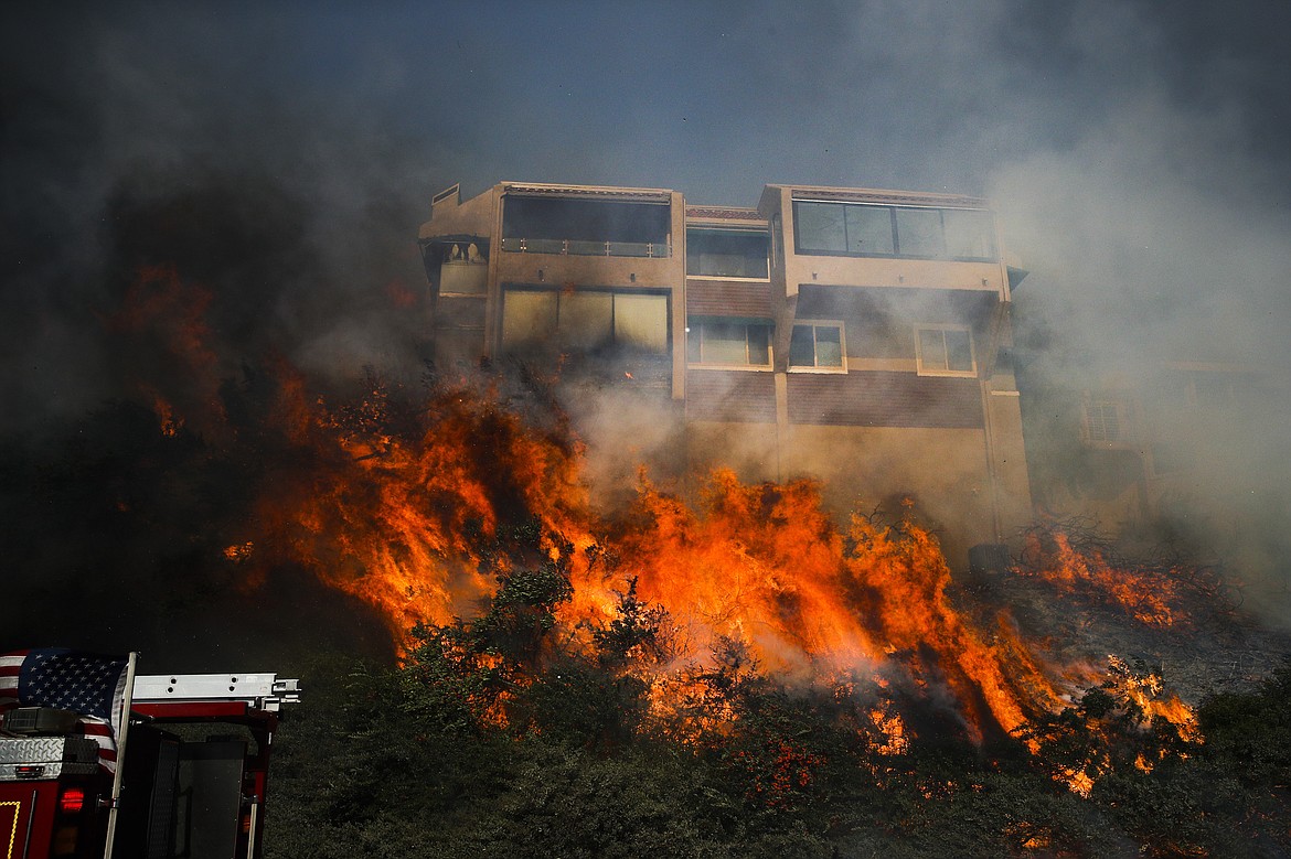 FILE - In this Dec. 5, 2017, file photo, a wildfire threatens a home in Ventura, Calif. If House Republicans have their way, victims of hurricanes in Texas and Florida could deduct their losses on their taxes. But victims of the California wildfires no longer could. (AP Photo/Jae C. Hong, File)