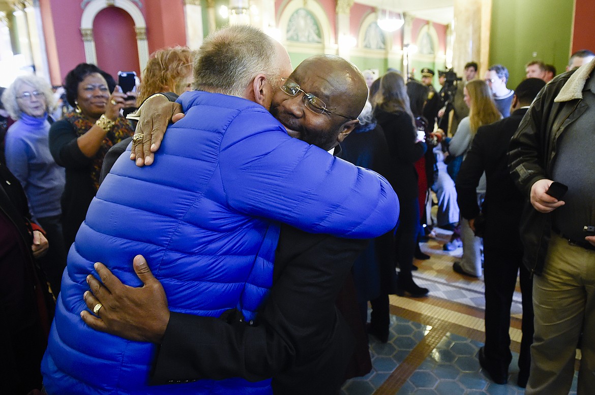 Mayor Wilmot Collins, right, hugs a supporter after he was sworn in Tuesday morning, Jan. 2, 2018, in Helena, Mont. Collins is a Liberian refugee who was elected mayor of Helena in November. (Thom Bridge/Independent Record via AP)