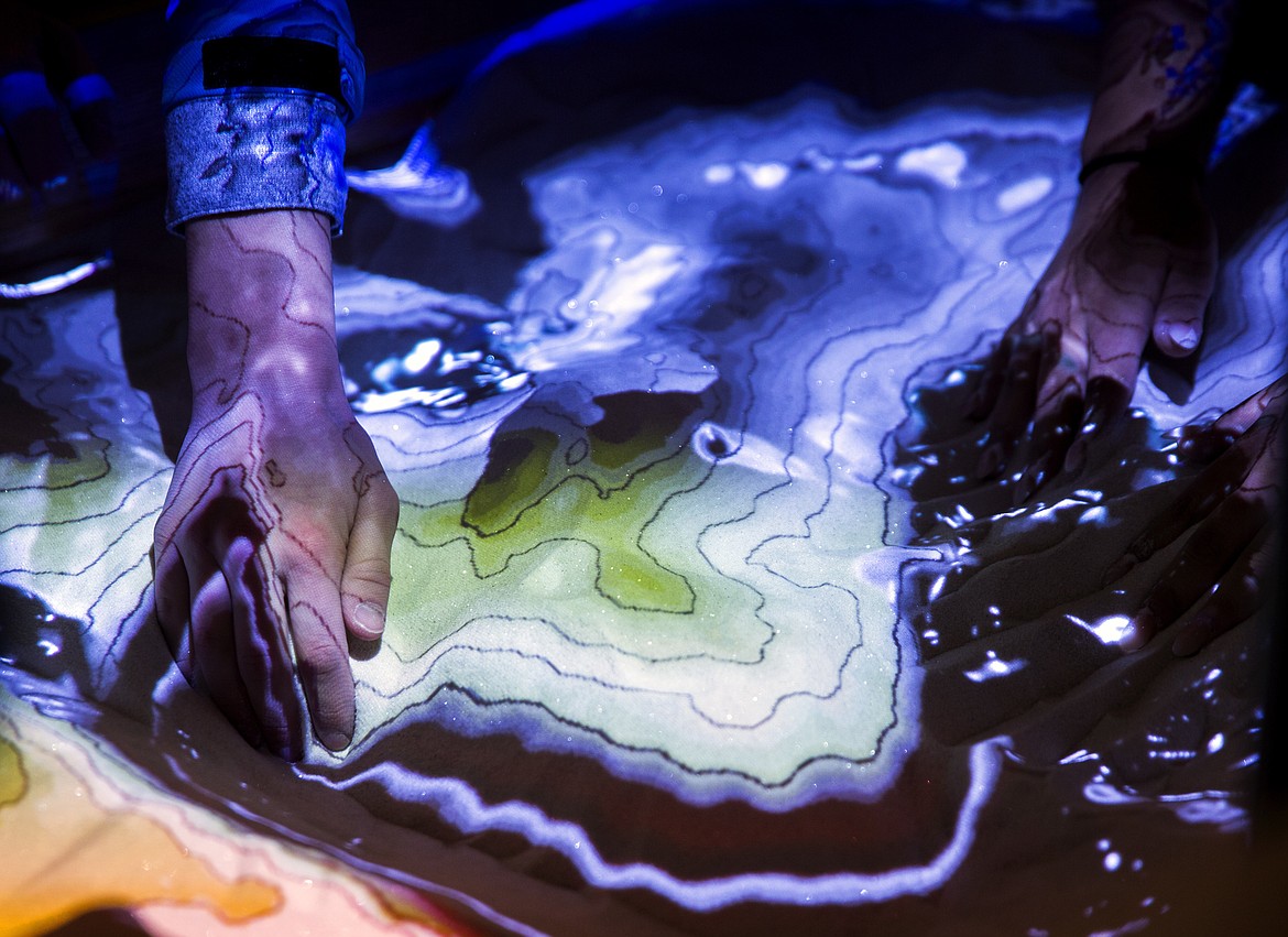 In a Thursday, Jan. 11, 2018 photo, senior Senior Taylor Bullock shifts sands to create different topographies in the augmented reality sandbox, at the Idaho School for the Deaf and Blind in Gooding, Idaho. (Pat Sutphin/The Times-News via AP)