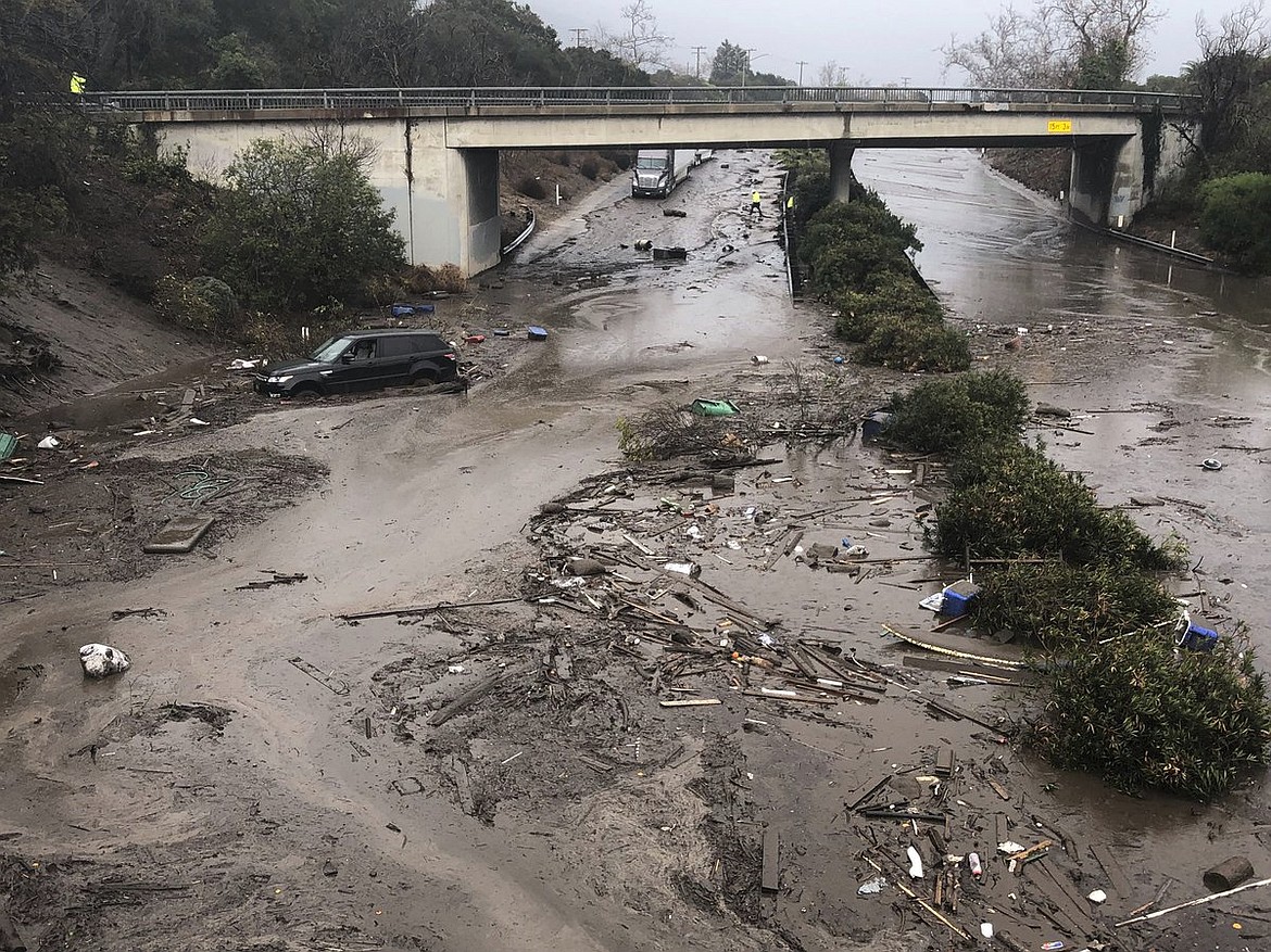 In this photo provided by Santa Barbara County Fire Department, U.S. Highway 101 at the Olive Mill Road overpass is flooded with runoff water from Montecito Creek in Montecito, Calif. on Tuesday, Jan. 9, 2018. Dozens of homes were swept away or heavily damaged Tuesday as downpours sent mud and boulders roaring down hills stripped of vegetation by a gigantic wildfire that raged in Southern California last month. (Mike Eliason/Santa Barbara County Fire Department via AP)