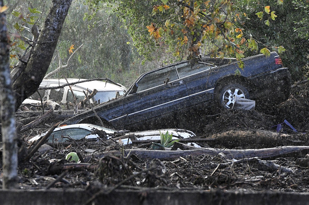 Cars that were washed away are piled up on the banks of Romero Creek in Montecito, Calif., Tuesday, Jan. 9, 2018. Dozens of homes were swept away or heavily damaged Tuesday as downpours sent mud and boulders roaring down hills stripped of vegetation by a gigantic wildfire that raged in Southern California last month. (AP Photo/Michael Owen Baker)