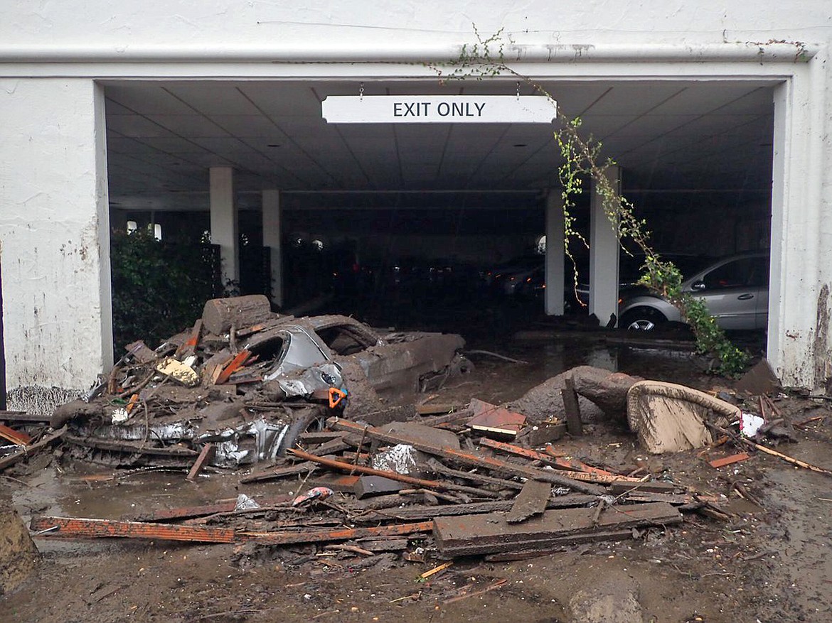 This photo provided by the Santa Barbara County Fire Department shows damaged vehicles carried by mud flow and debris at the parking garage of The Montecito Inn in Montecito, Calif., Tuesday, Jan. 9, 2018. Several homes were swept away before dawn Tuesday when mud and debris roared into neighborhoods in Montecito from hillsides stripped of vegetation during the Thomas wildfire. (Mike Eliason/Santa Barbara County Fire Department via AP)