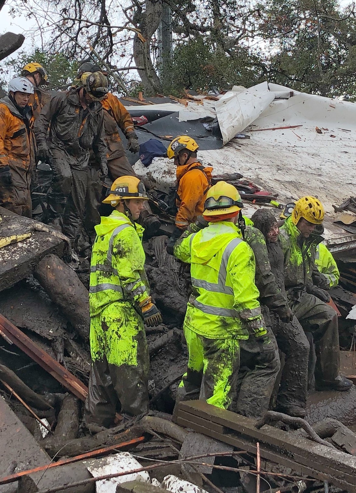 In this photo provided by Santa Barbara County Fire Department, firefighters successfully rescue a 14-year-old girl, right, after she was trapped for hours inside a destroyed home in Montecito, Calif., Tuesday, Jan. 9, 2018. Dozens of homes were swept away or heavily damaged and several people were killed Tuesday as downpours sent mud and boulders roaring down hills stripped of vegetation by a gigantic wildfire that raged in Southern California last month. (Mike Eliason/Santa Barbara County Fire Department via AP)