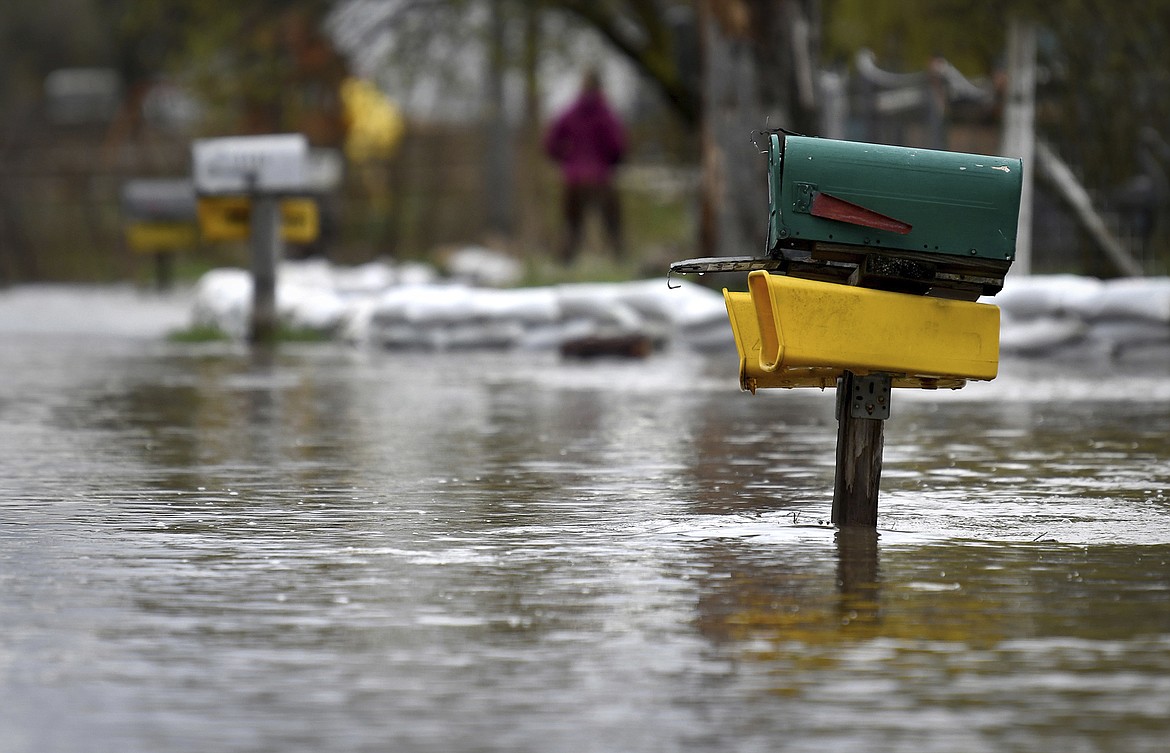 Flood waters from the nearby Clark Fork River flow down Kehrwald Drive off Tower Street on the west side of Missoula, Mont., Monday, April 30, 2018. Last week's warmer temperatures and weekend rain swelled several area rivers and creeks causing some minor flooding.  (Kurt Wilson/The Missoulian via AP)