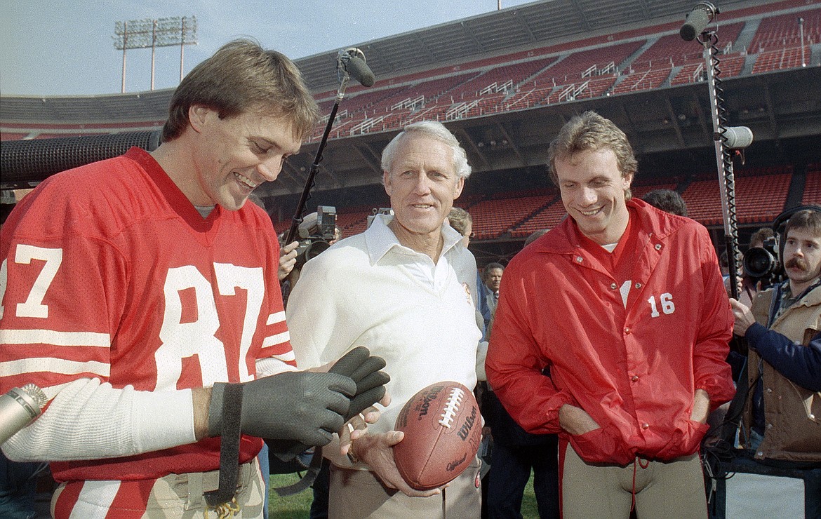 FILE - In this Jan. 16, 1985, file photo, San Francisco 49ers' head coach Bill Walsh, center, laughs with quarterback Joe Montana (16) and receiver Dwight Clark, left, at San Francisco's Candlestick Park. Clark, the former 49ers wide receiver whose reception known as &quot;The Catch&quot; sent San Francisco to its first Super Bowl, has died one year after revealing he had ALS. He was 61. The team said Clark died Monday, June 4, 2018, surrounded by friends and family.(AP Photo, File)