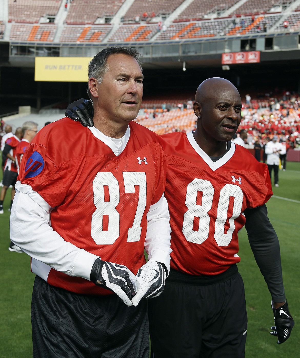 FILE - In this July 12, 2014, file photo, former San Francisco 49ers wide receivers Dwight Clark, left, and Jerry Rice, right, walk together on the field before the &quot;Legends of Candlestick&quot; flag football game in San Francisco. Clark, the former 49ers wide receiver whose reception known as &quot;The Catch&quot; sent San Francisco to its first Super Bowl, has died one year after revealing he had ALS. He was 61. The team said Clark died Monday, June 4, 2018, surrounded by friends and family. (AP Photo/Eric Risberg, File)