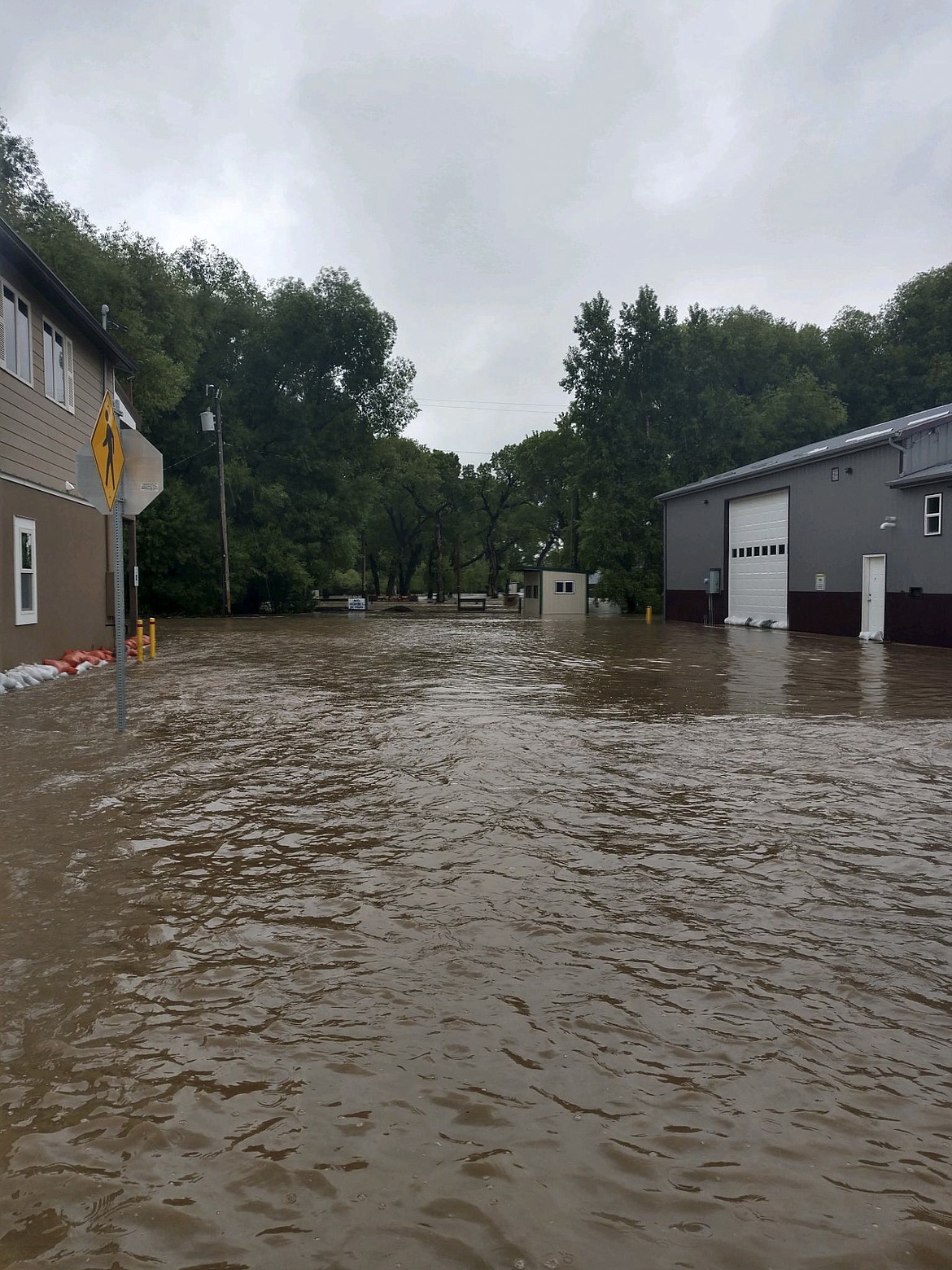 In this photo provided by the Lewis and Clark County Sheriff&#146;s Office, Main Street in Augusta, Mont. is awash after Elk Creek flooded Tuesday, June 19, 2018, closing all roads into the town of about 300 along the Rocky Mountain Front. (Jerome Steiner/Lewis and Clark County Sheriff&#146;s Office)