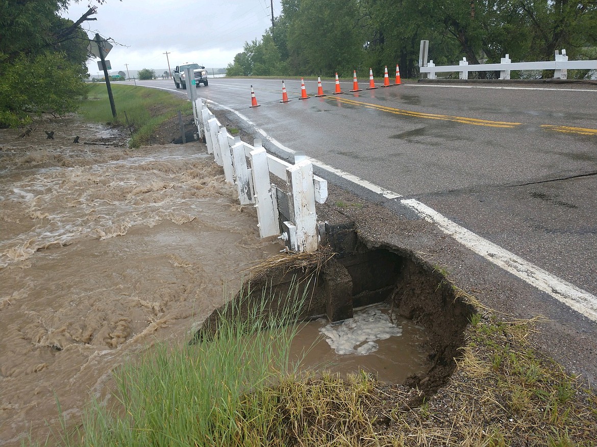 In this photo provided by the Lewis and Clark County Sheriff&#146;s Office, flood waters undercut a bridge along Highway 21 northeast of Augusta, Mont. on Tuesday, June 19, 2018. The bridge later washed out. Heavy rains in the area over the past few days caused flooding that closed all roads into the town of 300 along the Rocky Mountain Front. (Jerome Steiner/Lewis and Clark County Sheriff&#146;s Office)