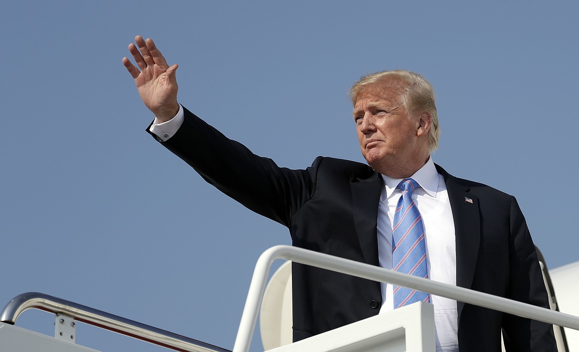 FILE - In this July 3, 2018 file photo President Donald Trump waves as he boards Air Force One at Andrews Air Force Base, Md. U.S. Sen. Jon Tester is giving Trump a tongue-in-cheek welcome to Montana by taking out a full-page ad in 14 newspapers thanking the president for signing 16 bills that the Democrat sponsored or co-sponsored. Trump was scheduled to hold a rally Thursday, July 5, 2018, in Great Falls to campaign for Tester&#146;s Republican challenger, State Auditor Matt Rosendale. The president has made the Montana Senate race a priority after he blamed Tester for derailing the nomination of his first Veterans Affairs nominee, White House physician Ronny Jackson. (AP Photo/Evan Vucci, File)