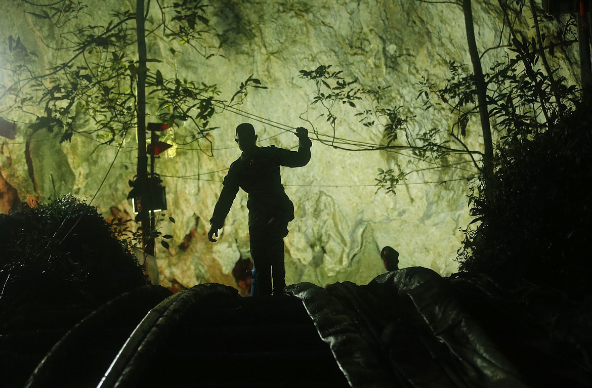 A rescuer makes his way down at the entrance to a cave complex where 12 boys and their soccer coach went missing, in Mae Sai, Chiang Rai province, in northern Thailand, Monday, July 2, 2018. Rescue divers are advancing in the main passageway inside the flooded cave in northern Thailand where the boys and their coach have been missing more than a week. (AP Photo/Sakchai Lalit