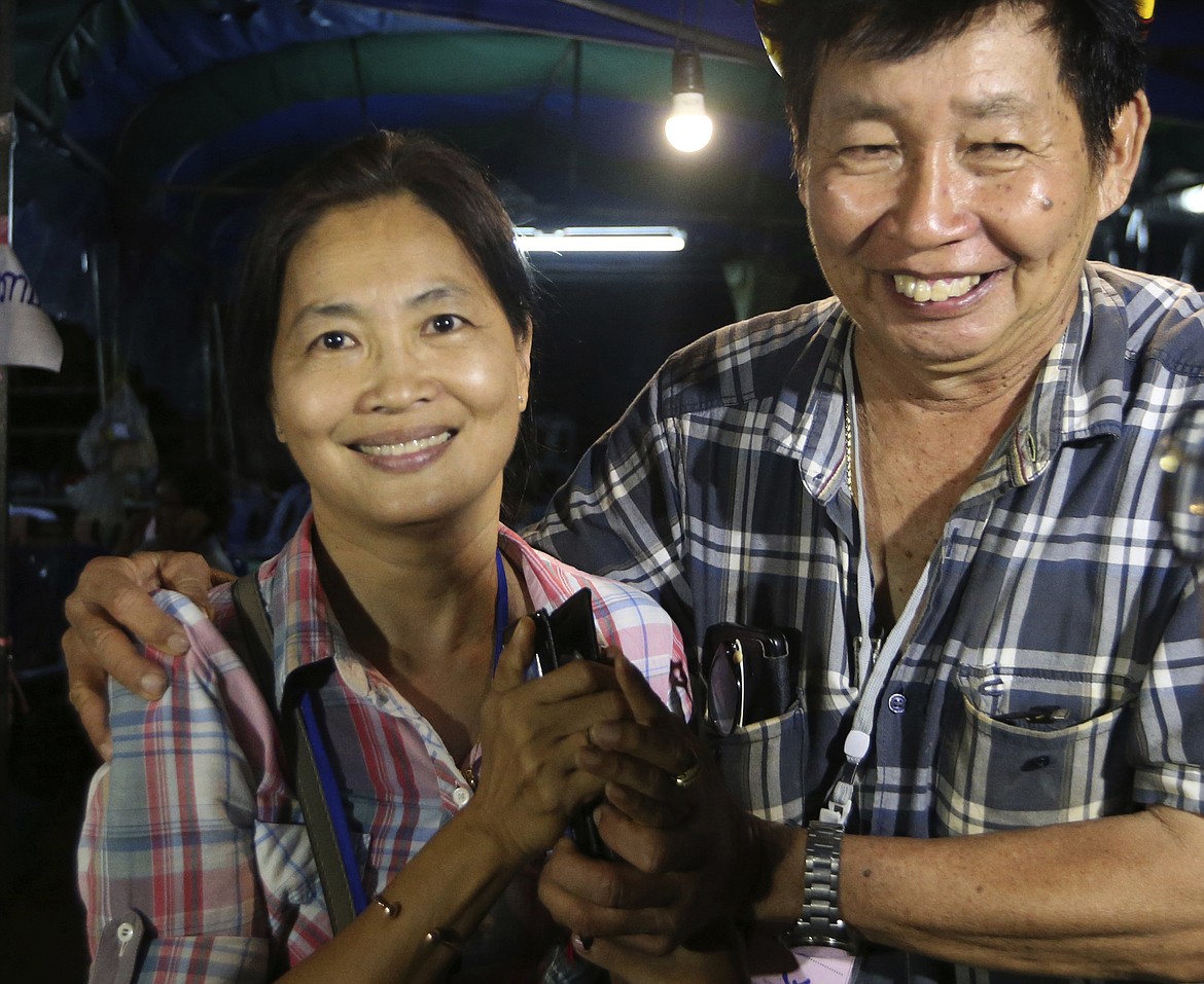 Family members smile after hearing the news that the missing 12 boys and their soccer coach have been found, in Mae Sai, Chiang Rai province, in northern Thailand, Monday, July 2, 2018. A Thai provincial governor says all 12 boys and their coach have been found alive in the cave where they went missing over a week ago in northern Thailand. (AP Photo/Sakchai Lalit)