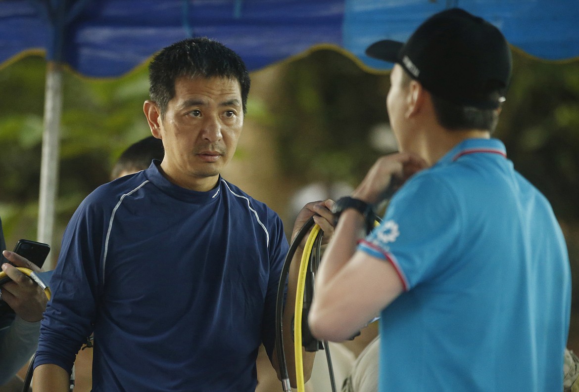 Chinese rescues team members talk near a cave complex where 12 boys and their soccer coach went missing, in Mae Sai, Chiang Rai province, in northern Thailand, Monday, July 2, 2018. Rescue divers are advancing in the main passageway inside the flooded cave in northern Thailand where the boys and their coach have been missing more than a week. (AP photo/Sakchai Lalit)