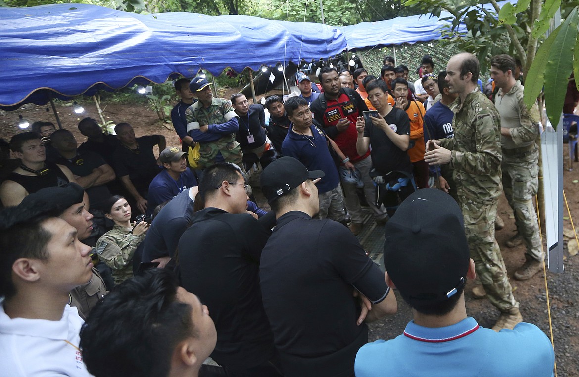 Personnels, right, of U.S. Special Operations Command Pacific Search and Rescue team meet with rescue teams from China, Thailand and Australia as they conduct search operation for missing 12 boys and their soccer coach, in Mae Sai, Chiang Rai province, in northern Thailand, Monday, July 2, 2018. Rescue divers are advancing in the main passageway inside the flooded cave in northern Thailand where the boys and their coach have been missing more than a week. (AP Photo/Sakchai Lalit)