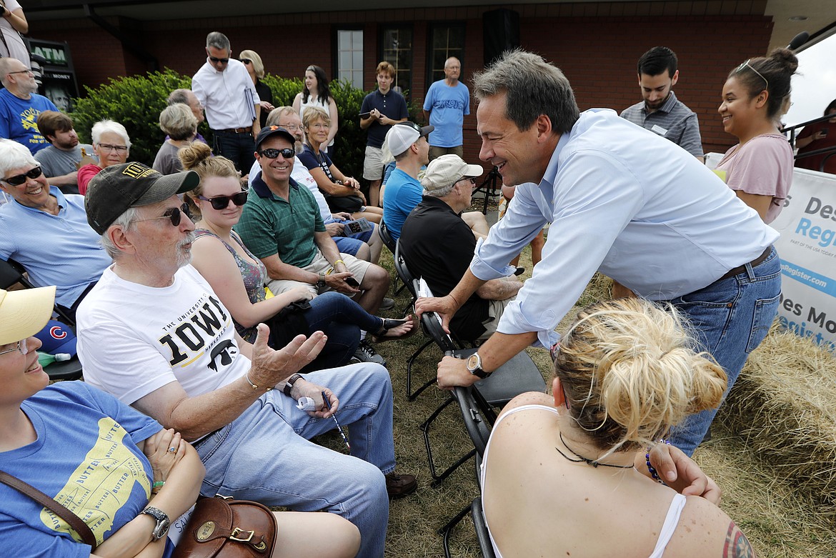 Montana Gov. Steve Bullock talks with Richard Juel, of Pittsburgh, Penn., left, during a visit to the Iowa State Fair, Thursday, Aug. 16, 2018, in Des Moines, Iowa. (AP Photo/Charlie Neibergall)