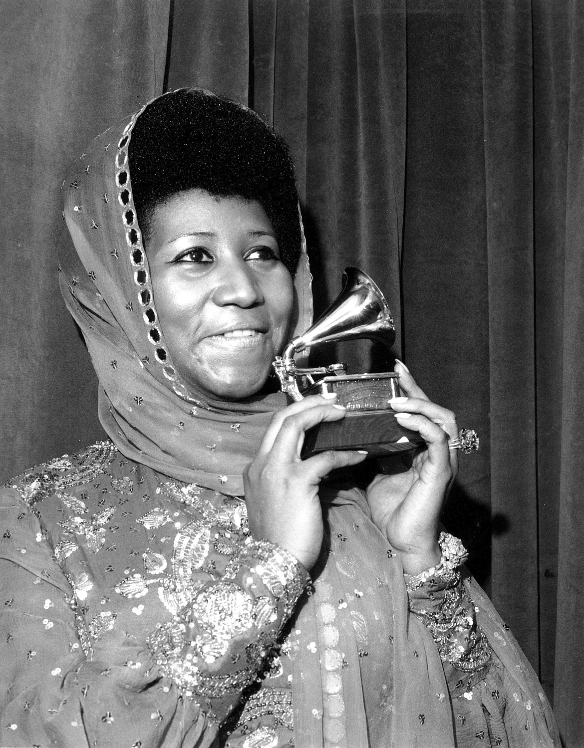 FILE - In this March 3, 1975 file photo, singer Aretha Franklin poses with her Grammy Award for for best female R&amp;B vocal performance for &quot;Ain't Nothing Like the Real Thing&quot; at the 17th Annual Grammy Award presentation in New York.   Franklin died Thursday, Aug. 16, 2018 at her home in Detroit.  She was 76. (AP Photo, File)