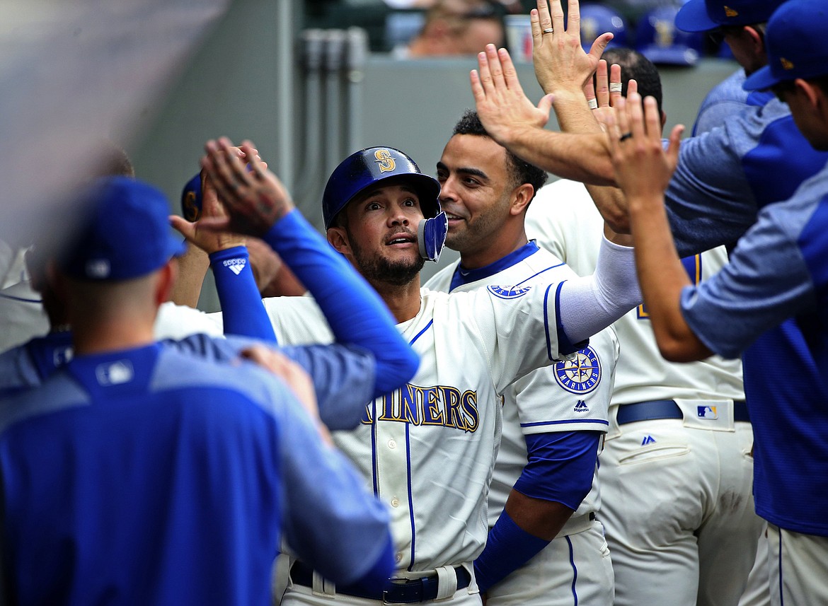 Seattle Mariners second baseman Kristopher Negron celebrates his run in the dugout after being knocked in by catcher David Freitas to get the M's on the board in the second inning against the Texas Rangers on Sunday, Sept. 30, 2018, in Seattle, Wash. (Ken Lambert/Seattle Times/TNS)