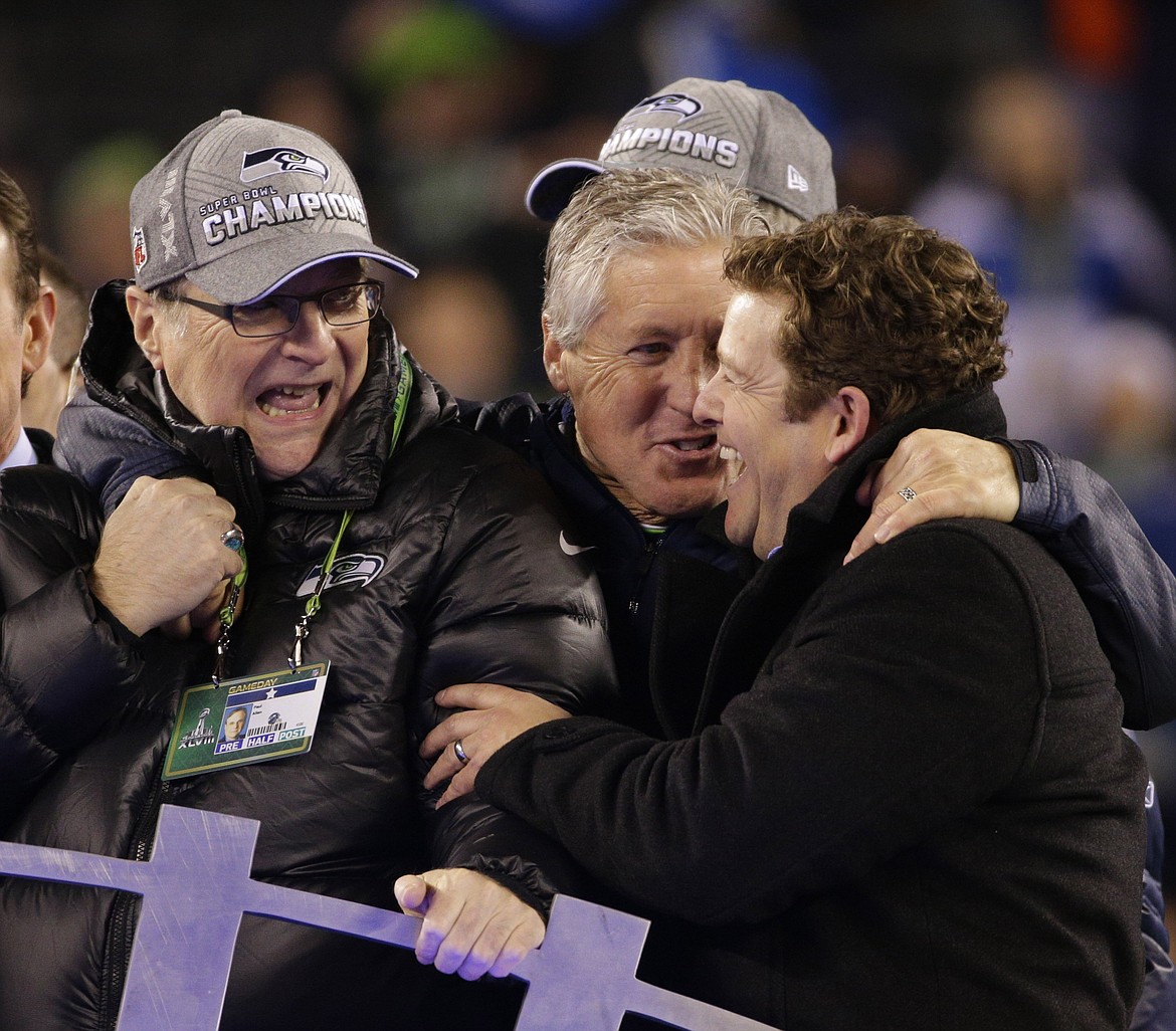 From left, Seattle Seahawks team owner Paul Allen, head coach Pete Carroll and general manager John Schneider celebrate on the trophy stand after a 43-8 victory against the Denver Broncos in Super Bowl XLVIII at MetLife Stadium in East Rutherford, N.J., on Sunday, Feb. 2, 2014. (Mark Cornelison/Lexington Herald-Leader/MCT)