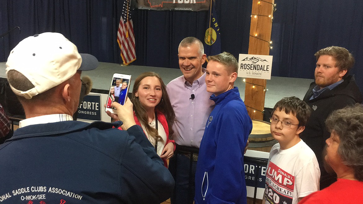 In this Friday, Oct. 26,2018 photo Republican Senate candidate Matt Rosendale poses for a photograph with supporters after a rally in East Helena, Mont. Rosendale is in a tight race against incumbent Democratic Sen. Jon Tester. (AP Photo/Matt Volz)