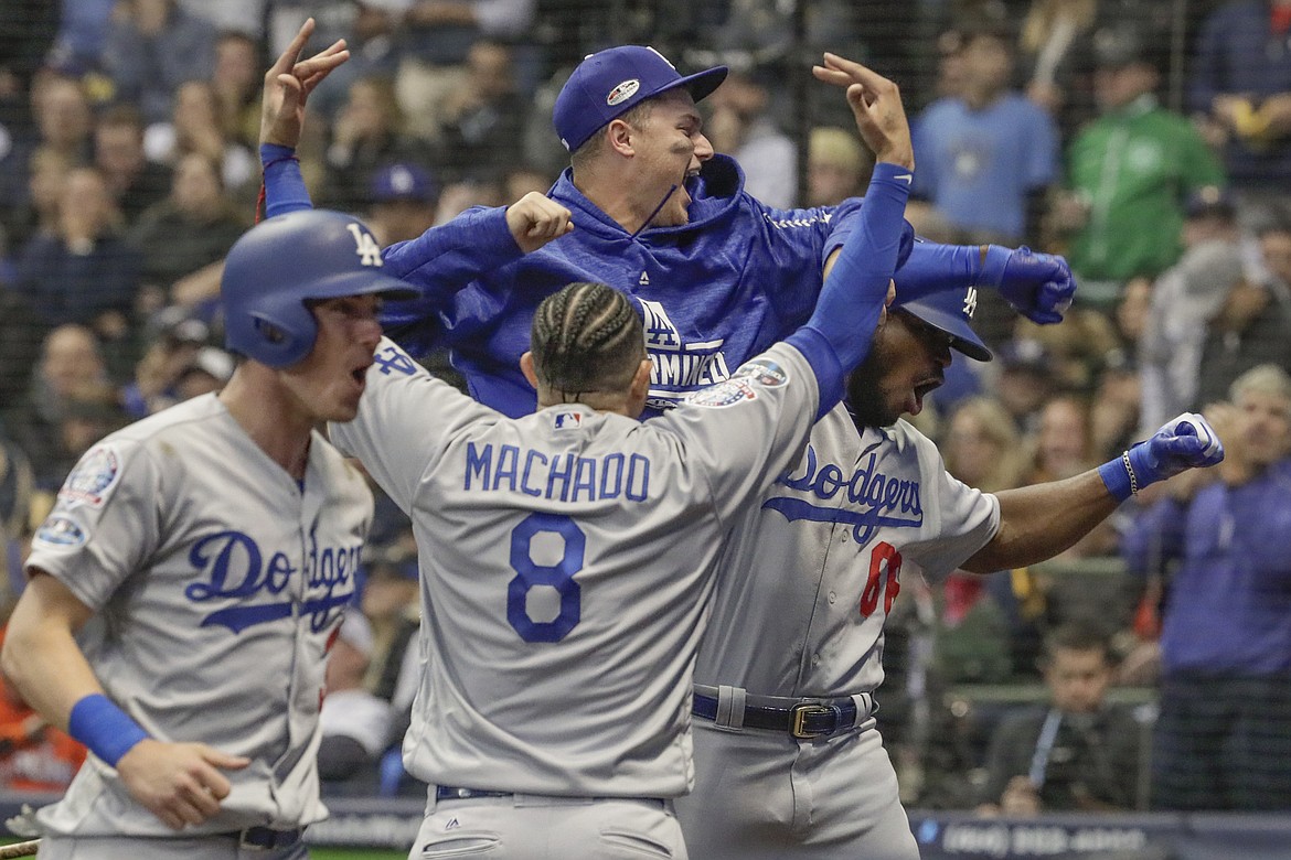 The Los Angeles Dodgers' Yasiel Puig, right, celebrates his three-run home run in the sixth inning against the Milwaukee Brewers during Game 7 of the National League Championship Series at Miller Park in Milwaukee on Saturday, Oct. 20, 2018. The Dodgers won, 5-1, to advance to the World Series. (Robert Gauthier/Los Angeles Times/TNS)