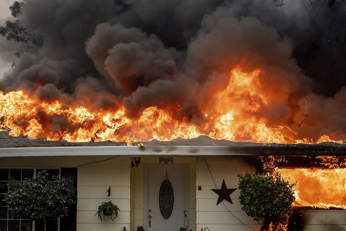 Flames consume a home as the Camp Fire tears through Paradise, Calif., on Thursday, Nov. 8, 2018. A California fire official says a fast-moving wildfire in Northern California has destroyed structures and injured civilians. (AP Photo/Noah Berger)