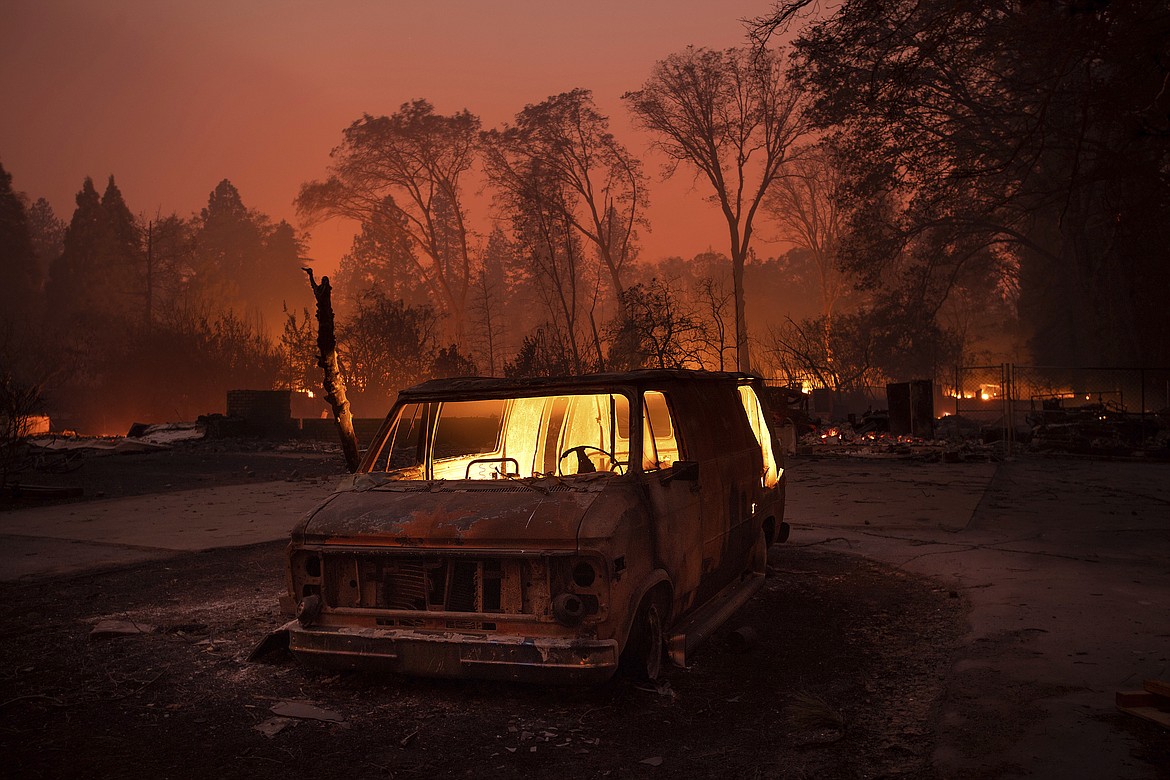 Flames burn inside a van as the Camp Fire tears through Paradise, Calif., on Thursday, Nov. 8, 2018. Tens of thousands of people fled a fast-moving wildfire Thursday in Northern California, some clutching babies and pets as they abandoned vehicles and struck out on foot ahead of the flames that forced the evacuation of an entire town and destroyed hundreds of structures. (AP Photo/Noah Berger)