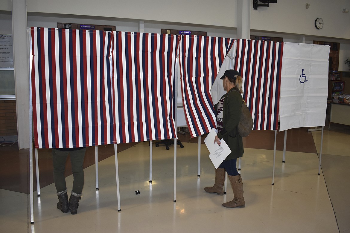 A voter enters a voting booth at Laurel High School on Tuesday, Nov. 6, 2018, in Laurel, Mont. (AP Photo/Matthew Brown) (AP Photo/Matthew Brown)