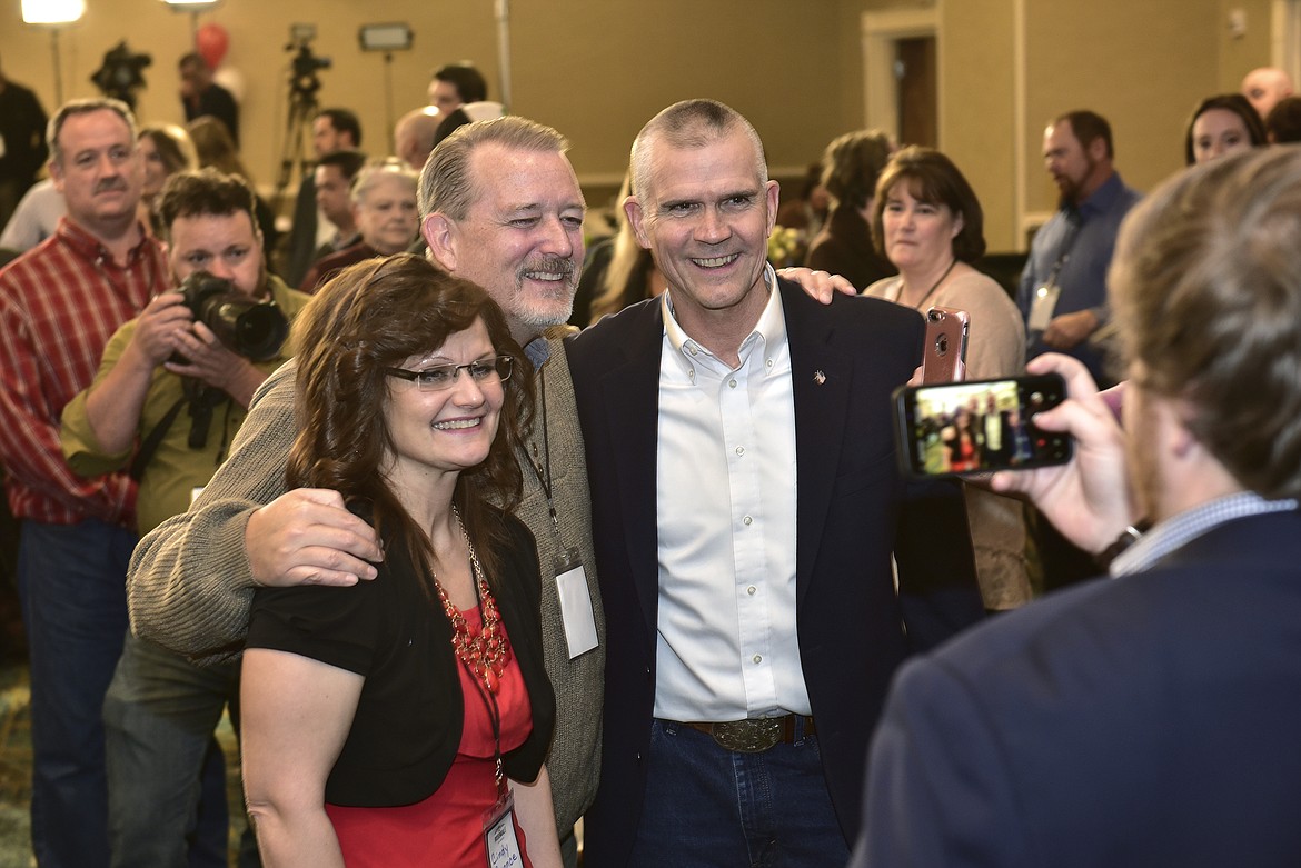 Cindy Cronce, left, and Curt Edlin, center, of Helena, pose for a picture with Senate candidate Matt Rosendale after he greeted the room to say it would be a long night Tuesday, Nov. 6, 2018, in the Delta Hotel in Helena, Mont. Rosendale is challenging Sen. Jon Tester, D-Mont. (AP Photo/ Eliza Wiley)