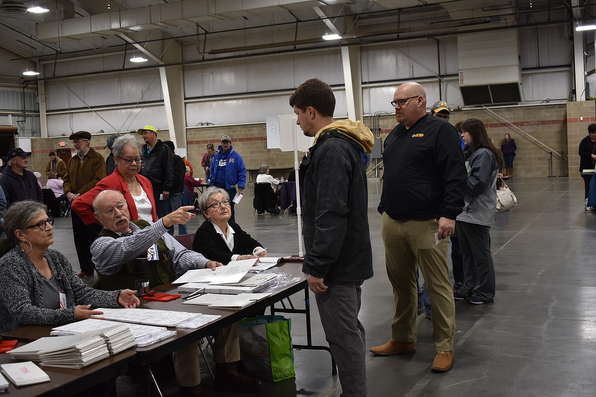 An election worker directs a voter toward a booth to fill out his ballot at the Montana Pavilion at MetraPark on election day, Tuesday, Nov. 6, 2018, in Billings, Mont. (AP Photo/Matthew Brown)