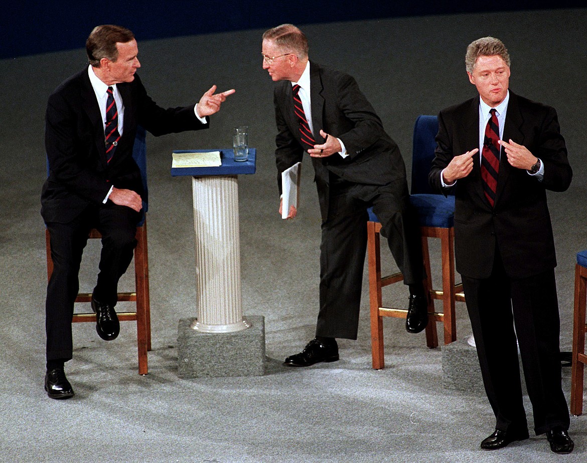 FILE - In this Oct. 15, 1992, file photo, President George H.W. Bush, left, talks with independent candidate Ross Perot as Democratic candidate Bill Clinton stands aside at the end of their second presidential debate in Richmond, Va. Bush died at the age of 94 on Friday, Nov. 30, 2018, about eight months after the death of his wife, Barbara Bush. (AP Photo/Marcy Nighswander, File)