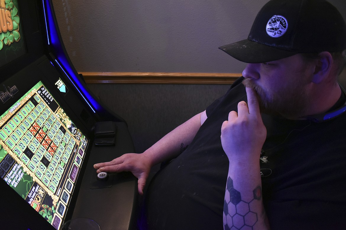 Eric Wieland ponders his next play on a video poker machine at the Palm Grand Casino in Billings, Mont., Tuesday, April 23, 2019. Wieland says he's likely to try sports betting as Montana is poised to legalize it. (AP Photo/Matthew Brown)