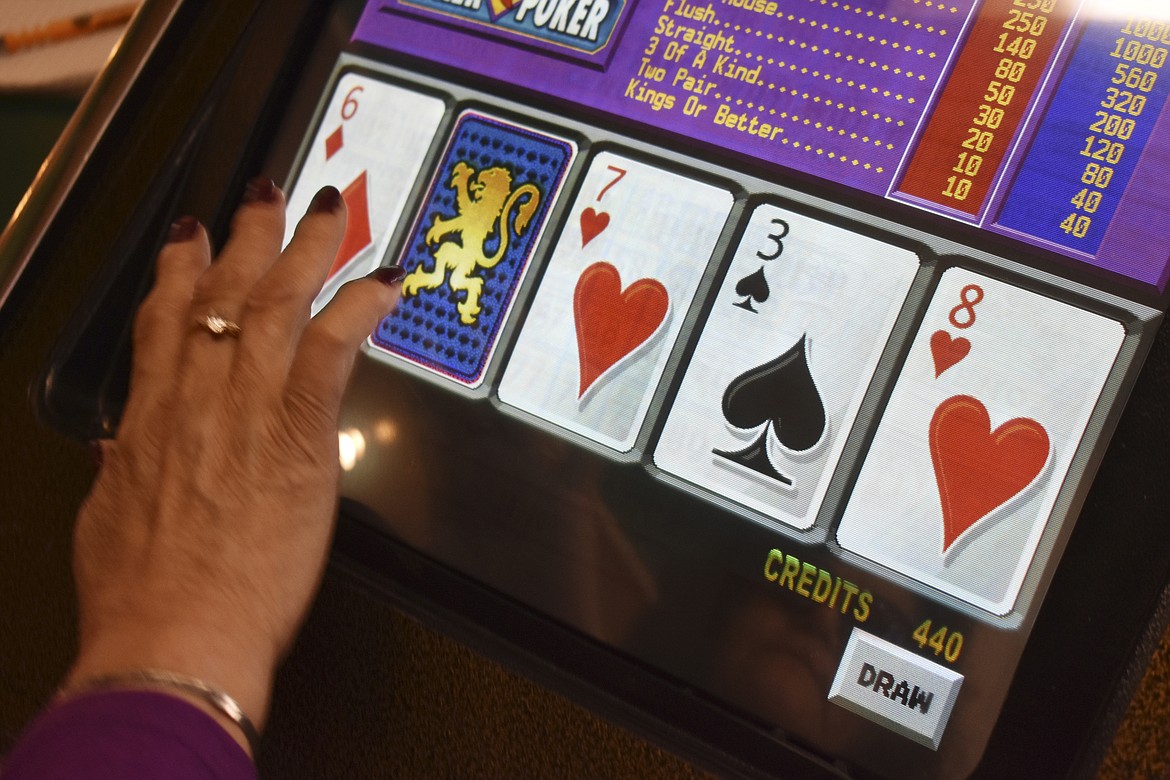 A player swipes the screen on a video poker machine at the Monte Bar and Casino in Billings, Montana, Tuesday, April 23, 2019. Almost a year after the U.S. Supreme Court ended Nevada's monopoly on sports betting, Montana, Iowa and Indiana are poised to legalize sports betting. (AP Photo/Matthew Brown)