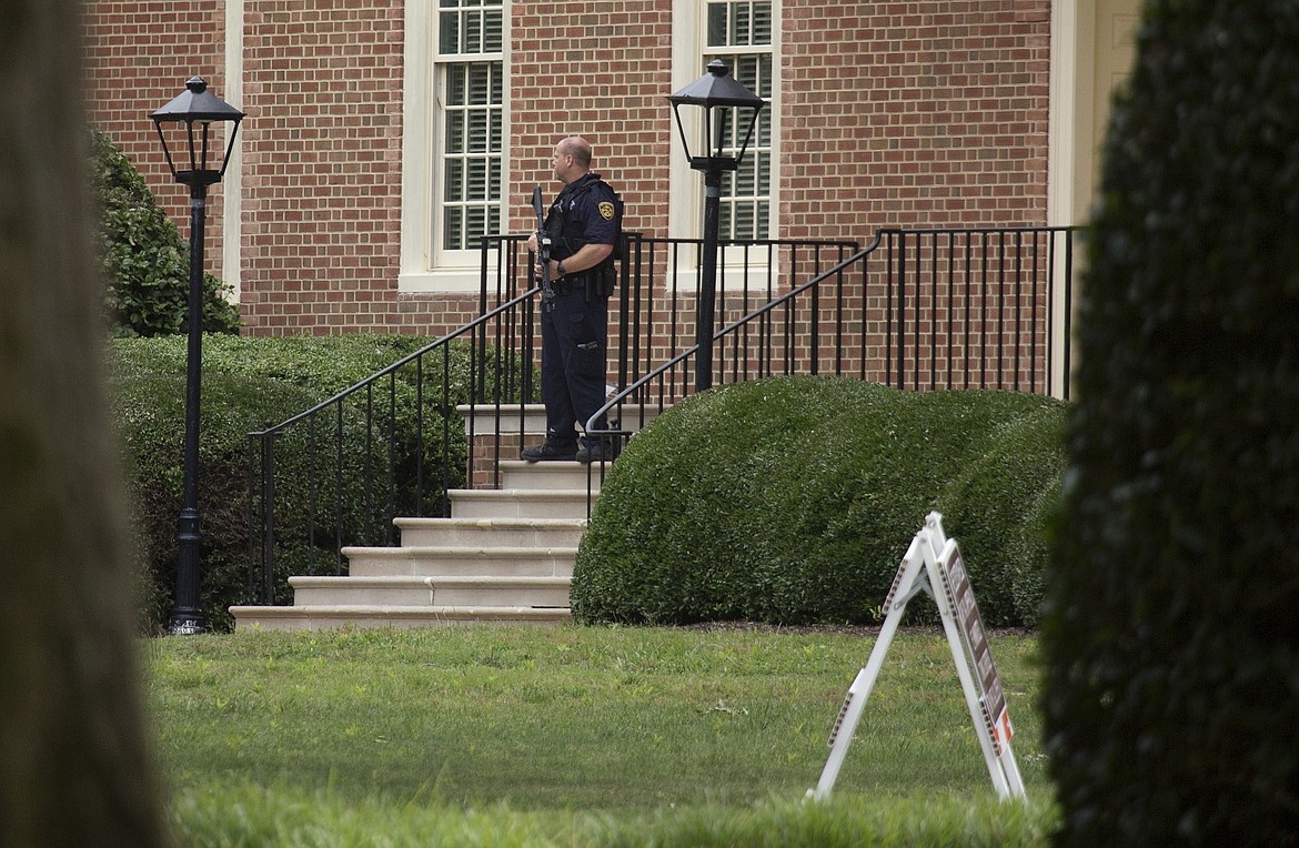 A police officer stands out in front of City Hall next to the building where eleven people were killed during a mass shooting at the Virginia Beach city public works building, Friday, May 31, 2019 in Virginia Beach, Va. A longtime, disgruntled city employee opened fire at a municipal building in Virginia Beach on Friday, killing 11 people before police fatally shot him, authorities said.  Six other people were wounded in the shooting, including a police officer whose bulletproof vest saved his life, said Virginia Beach Police Chief James Cervera. (L. Todd Spencer/The Virginian-Pilot via AP)